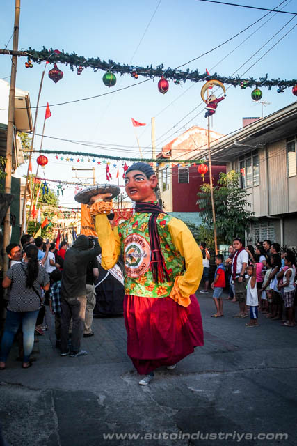 A higantes effigy carrying a bilao of pancit